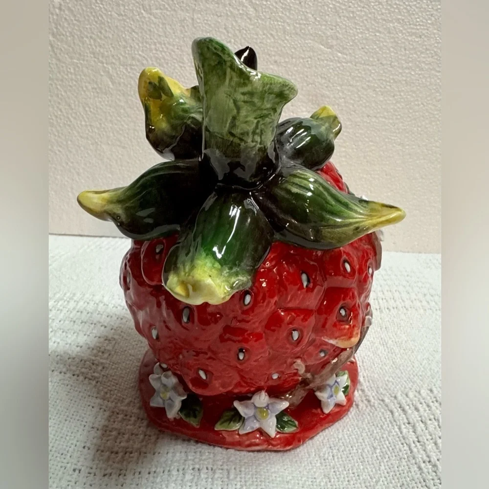 This is a vintage ceramic strawberry candle or tealight holder,